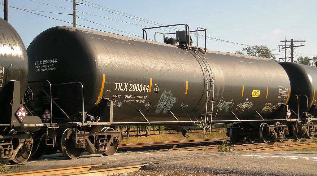 A black tanker car sits on a train track.