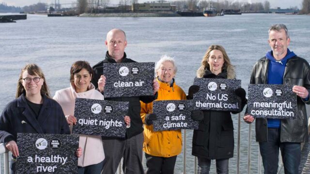 A group of people hold signs up that relate to coal.