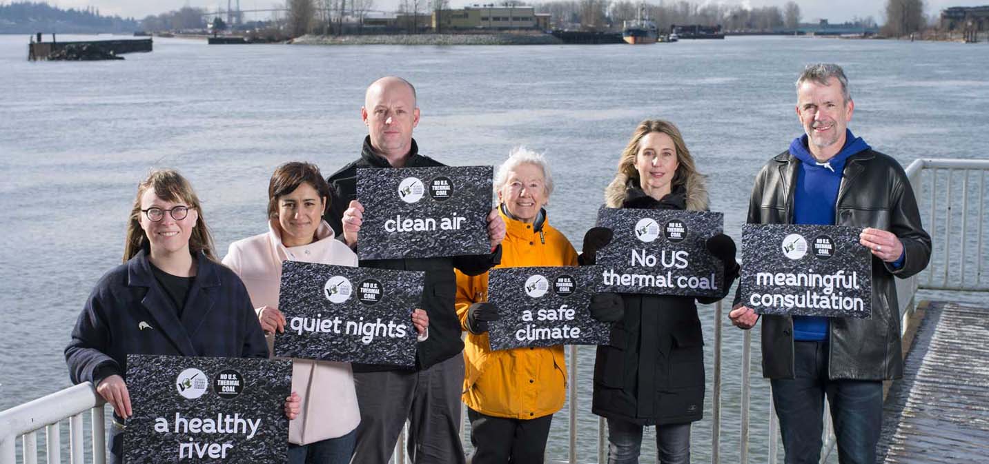 A group of people hold signs up that relate to coal.