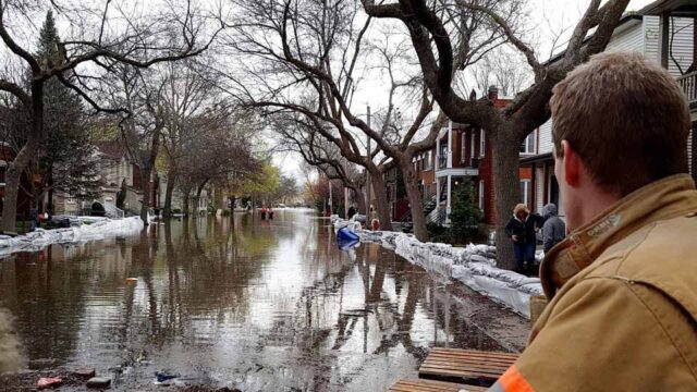 Person surveys flooded residential street