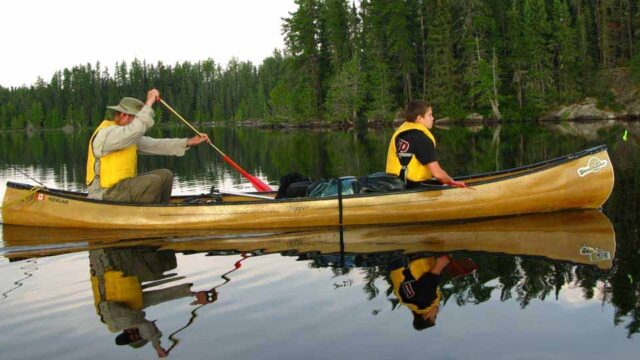 Paddlers canoeing on lake.