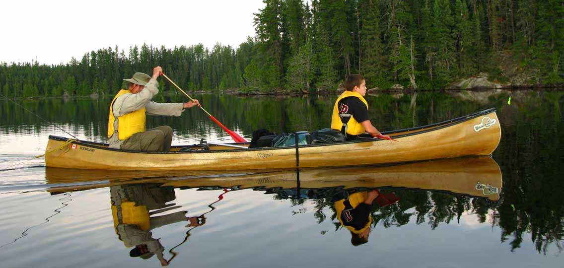 Paddlers canoeing on lake.
