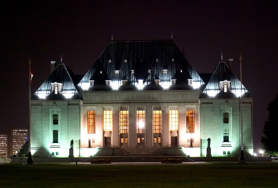 Canada's Supreme Court building at night is lit up.