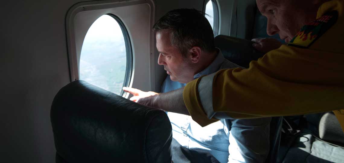 Premier Kenney looks out of the window on a plane.