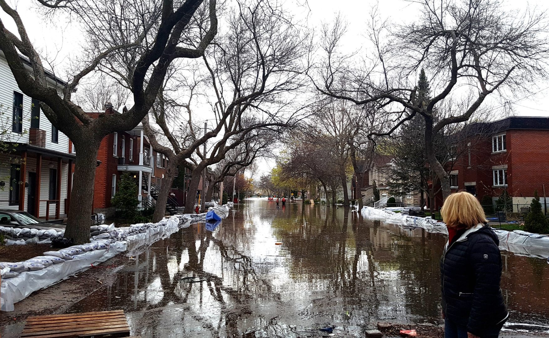 A person looks out at a flooded neighbourhood street.