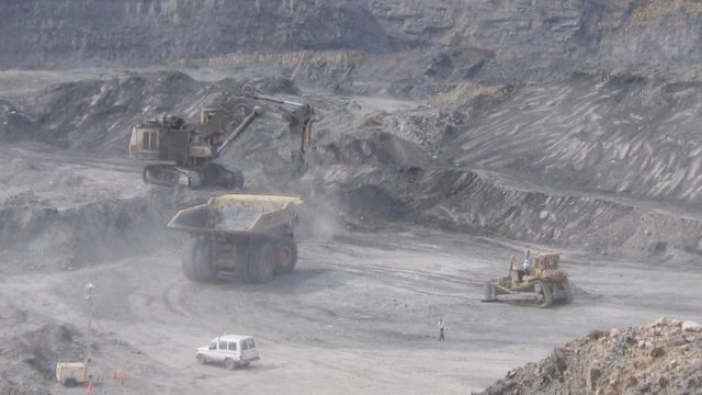 Heavy machinery operates in open-pit coal mine