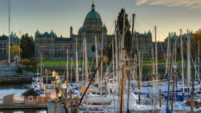 The docks at the Provincial legislature have many docked sail boats. Many boats have a different national flag.