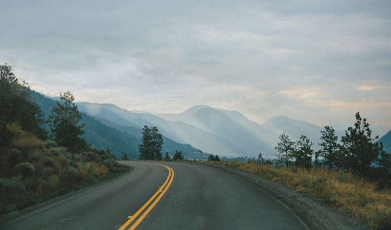 image of sunny mountains in british columbia with an overcast day, view from a vista by the road