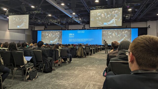A view from the back of a packed conference room at the global plastics treaty negotiations.